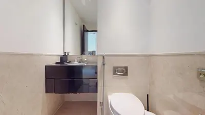 a bathroom with a white toilet and a sink at Vacationer l Bright 1 Bedroom l Marina & Yacht Views l Pool access & Free Wi-Fi in Dubai