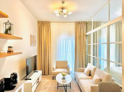 a living room with a couch and a tv at Golfville LighthouseDubai Hills in Dubai