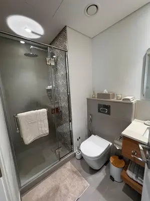 a bathroom with a shower and a toilet at Golfville LighthouseDubai Hills in Dubai