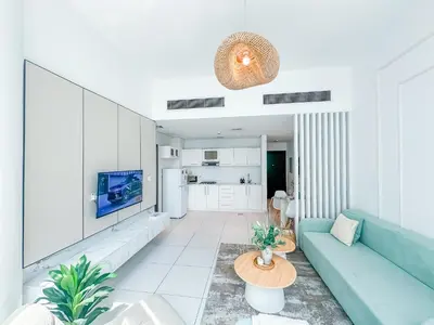 a living room with a blue couch and a table at Amazing Roof Top Pool in Nice 1 BHK Flat in Marina in Dubai