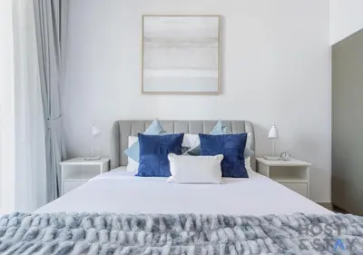 a bedroom with a large bed with blue and white pillows at Luxurious 2 BR- Dubai Creek Harbour - Host & Stay in Dubai