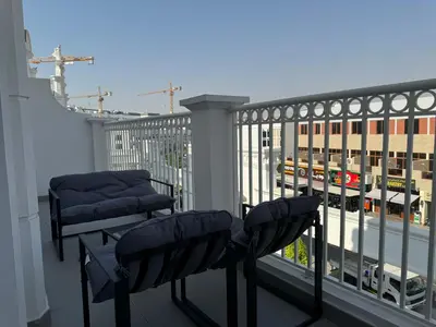 a balcony with two chairs and a view of a city at ASHRI Luxurious Apartment in Arjan near Miracle Gardens in Dubai