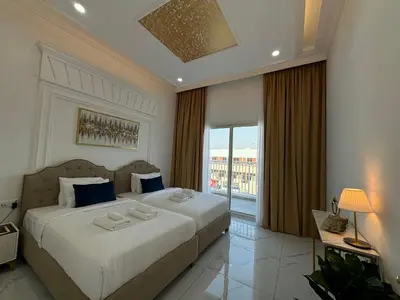 a bedroom with a large bed and a large window at ASHRI Luxurious Apartment in Arjan near Miracle Gardens in Dubai