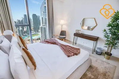 a bedroom with a white bed and a large window at Keysplease 3 BR Burj View, Dubai Mall Access Boulevard Point Tower in Dubai