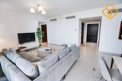 a living room with a large couch and a flat screen tv at Keysplease 3 BR Burj View, Dubai Mall Access Boulevard Point Tower in Dubai