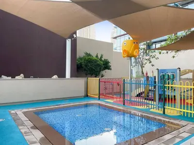 a pool with a colorful fence and a playground at Marina View 1BR Chic Stay in Dubai Vibrant Walk Near Dining & Attractions in Dubai