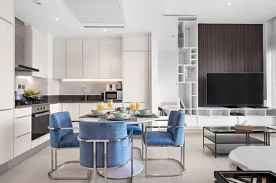 a kitchen with a table and blue chairs in it at Marina View 1BR Chic Stay in Dubai Vibrant Walk Near Dining & Attractions in Dubai