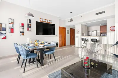 a dining room and living room with a table and chairs at Downtown 2BR Skyline Views & Prime Dubai Stay Near Burj Khalifa, Mall in Dubai