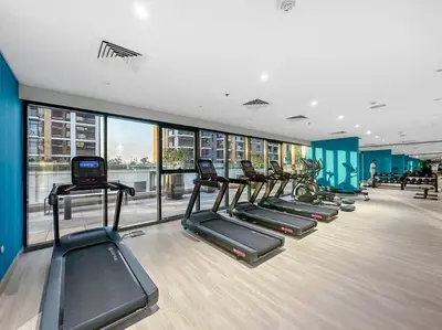 a gym with a row of treadmills in a building at FIRST CLASS Studio Sophisticated Getaway in Dubai