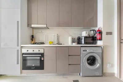 a kitchen with a washing machine and a dishwasher at StoneTree - Fully Furnished - Brand New in Dubai
