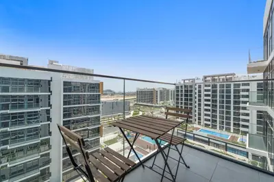 a table and two chairs on a balcony with buildings at StoneTree - Fully Furnished - Brand New in Dubai