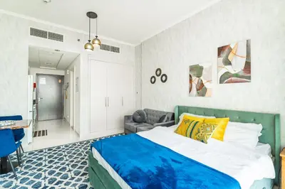 a bedroom with a bed and a couch at Studio in Damac Hills - Luxurious Living with Premium Amenities, by Think Realty in Dubai