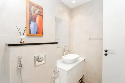 a bathroom with a white toilet and a sink at Studio in Damac Hills - Luxurious Living with Premium Amenities, by Think Realty in Dubai