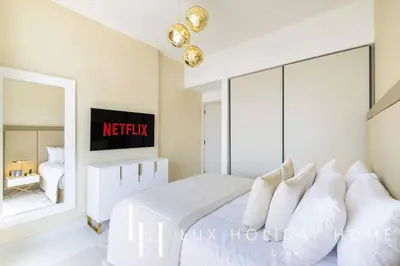 a bedroom with a white bed and a mirror at LUX The Marina Vista Beachfront Suite 3 in Dubai