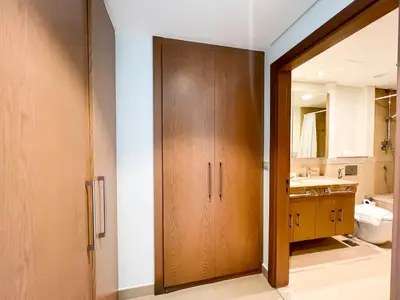 a bathroom with a wooden closet and a sink at Stylish 2BR Burj Khalifa & Fountain View Downtown - 37AB06 in Dubai