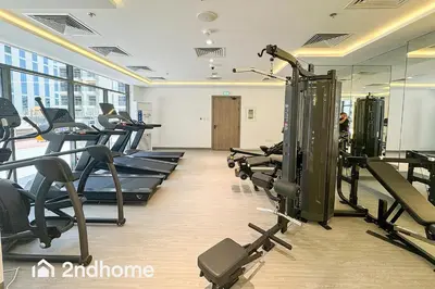a gym with treadmills and cardio equipment in a building at 2ndHome - Laya Heights, Studio City in Dubai