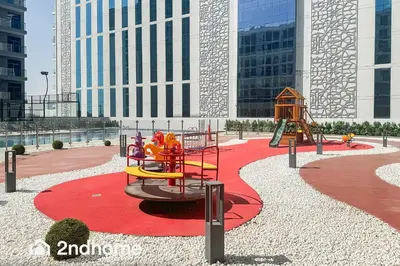 a playground with a slide on a red carpet at 2ndHome - Laya Heights, Studio City in Dubai