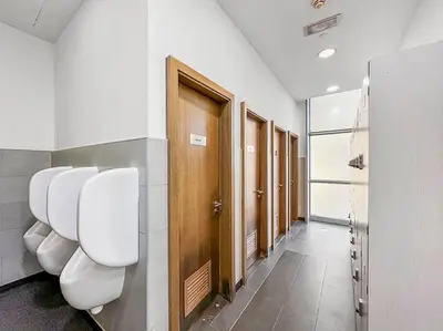a row of urinals in a bathroom with stalls at Luxury DIFC 1BR Near Dubai Mall, Burj Khalifa with Skyline Views in Dubai
