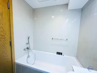 a white bathroom with a tub and a sink at 1BR Downtown Apt Walk to Dubai Mall & Burj in Dubai