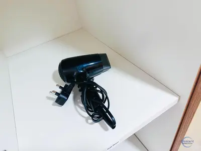 a black phone sitting on top of a shelf at 1BR Downtown Apt Walk to Dubai Mall & Burj in Dubai
