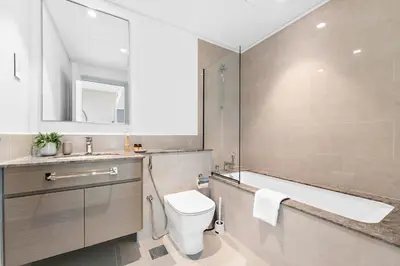 a bathroom with a toilet and a sink and a mirror at Silkhaus Beautiful 1 BDR in Heart of Downtown in Dubai