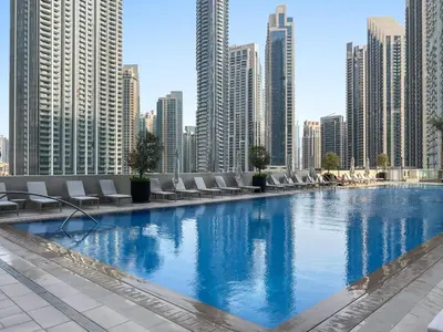 a large swimming pool in a city with tall buildings at Silkhaus Beautiful 1 BDR in Heart of Downtown in Dubai