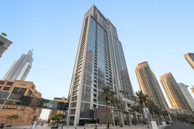 a tall building with palm trees in a city at Silkhaus Beautiful 1 BDR in Heart of Downtown in Dubai