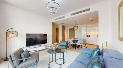 a living room with a blue couch and a dining room at Palace Residences - Chic Two Bed with Creek Views in Dubai