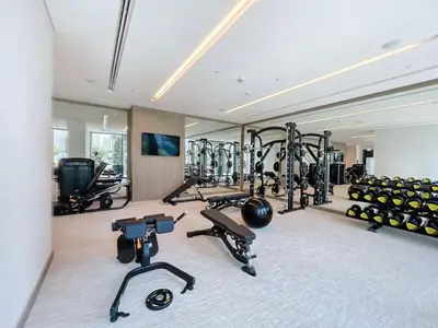 a gym with several treadmills and exercise bikes at Palace Residences - Chic Two Bed with Creek Views in Dubai