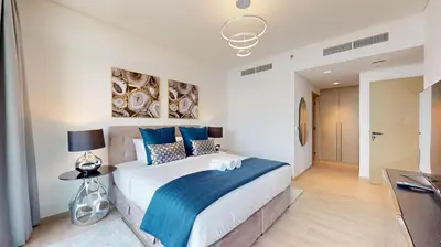 a bedroom with a large bed with a blue blanket at Palace Residences - Chic Two Bed with Creek Views in Dubai