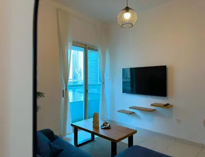 a living room with a blue couch and a table at DreamLike Full Pool & Marina View Apartment Dubai in Dubai