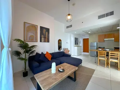a living room with a blue couch and a table at DreamLike Full Pool & Marina View Apartment Dubai in Dubai