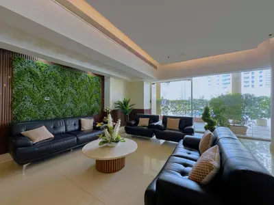 a living room with couches and a large green wall at DreamLike Full Pool & Marina View Apartment Dubai in Dubai