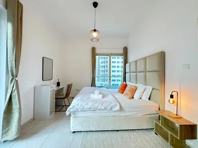 a bedroom with a large bed and a desk at DreamLike Full Pool & Marina View Apartment Dubai in Dubai