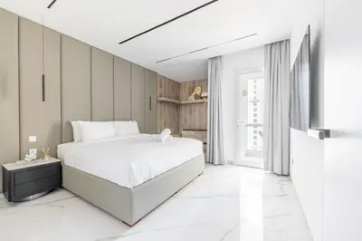 a white bedroom with a bed and a television at Seaside Elegance - NEW Luxury 3-Bedroom Apt in JBR in Dubai