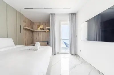 a white room with two beds and a television at Seaside Elegance - NEW Luxury 3-Bedroom Apt in JBR in Dubai