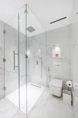 a white bathroom with a shower and a toilet at Seaside Elegance - NEW Luxury 3-Bedroom Apt in JBR in Dubai