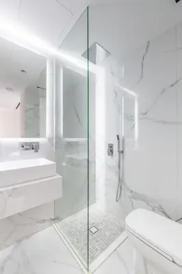 a white bathroom with a shower and a toilet at Seaside Elegance - NEW Luxury 3-Bedroom Apt in JBR in Dubai