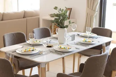 a dining room table with plates and wine glasses at Dubai Eye & Sea View, 1-min walk to JBR Beach, Luxurious Beach Retreat! in Dubai