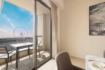 a room with a balcony with a table and chairs at Dubai Eye & Sea View, 1-min walk to JBR Beach, Luxurious Beach Retreat! in Dubai