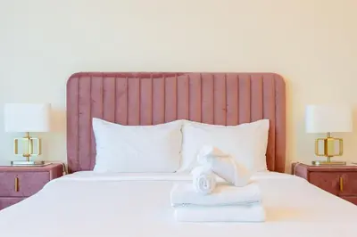 a bedroom with a bed with towels and two lamps at Dubai Modern Apartment l Sleeps 4 l 2 Baths in Dubai