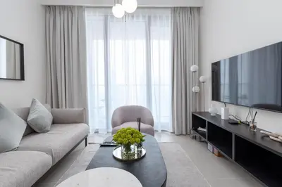 a living room with a couch and a tv at Luxury Escapes - Stylish 2BR Apt with City View in Forte Downtown in Dubai