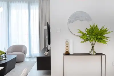 a living room with a console table with a plant on it at Luxury Escapes - Stylish 2BR Apt with City View in Forte Downtown in Dubai
