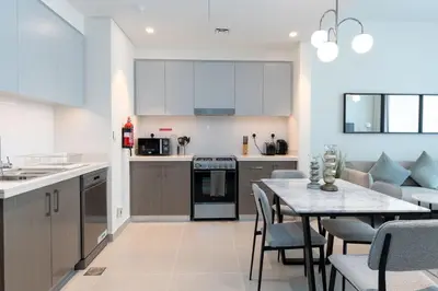 a kitchen and dining room with a table and chairs at Luxury Escapes - Stylish 2BR Apt with City View in Forte Downtown in Dubai