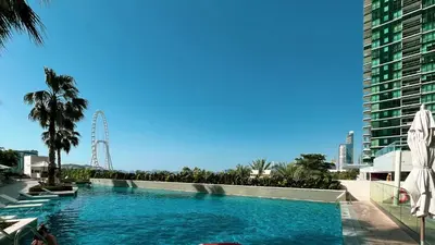 a swimming pool with a ferris wheel in the background at Address Beach Resort JBR - 1 BR in Dubai