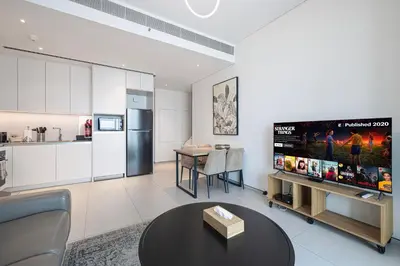 a living room with a tv and a kitchen at Address Beach Resort JBR - 1 BR in Dubai