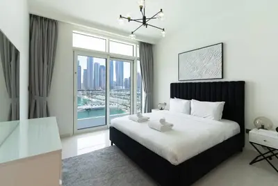 a bedroom with a large bed and a large window at 2 BR Private Beach Access & Marina View in Dubai