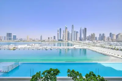 a large swimming pool with a city in the background at 2 BR Private Beach Access & Marina View in Dubai