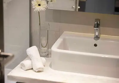 a bathroom sink with a vase with a flower in it at Lux Studio in Downtown - Damac Maison Prive - Near Burj Khalifa in Dubai