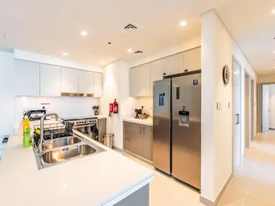 a kitchen with a sink and a refrigerator at the London Condo - Forte Downtown Dubai in Dubai